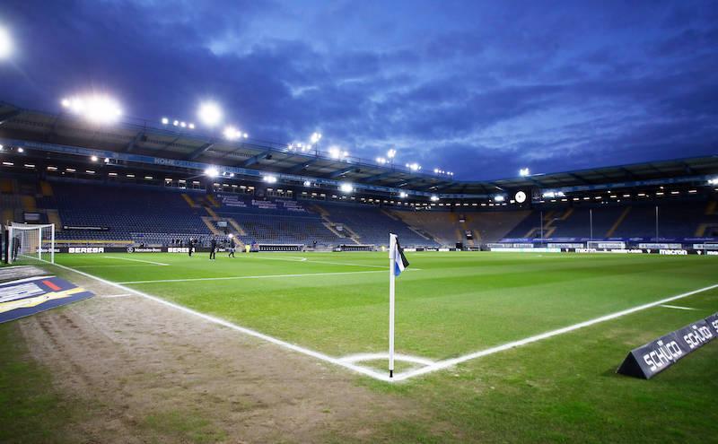 Aufnahme der SchücoArena mit Blick über das Spielfeld. Die Flutlichtanlage beleuchtet das Stadion.