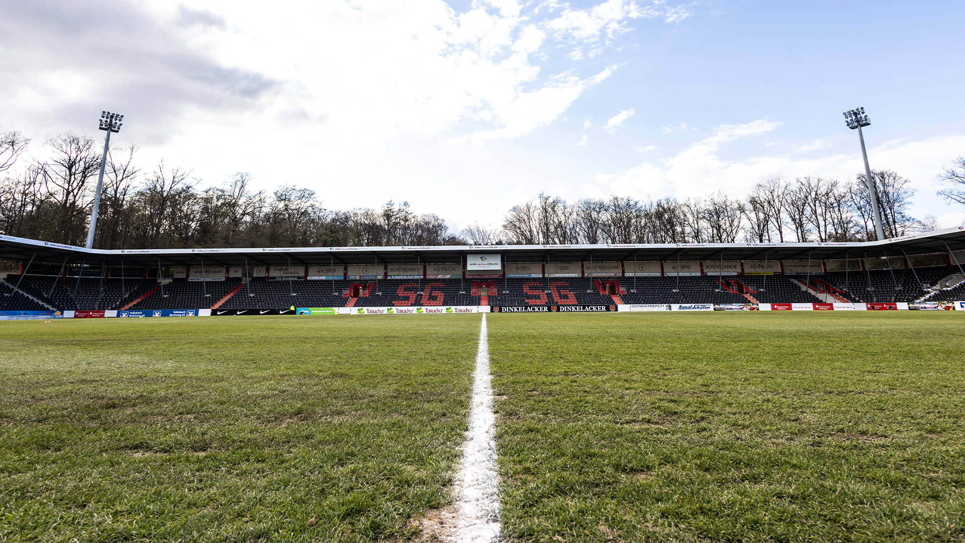 Die Tribüne des WIRmachenDRUCK-Arena in Großaspach, hinter der Tribüne steigt roter Rauch auf.