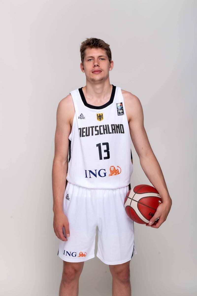 Moritz Wagner beim Fotoshooting. Wagner hält einen Ball in der linken Hand.