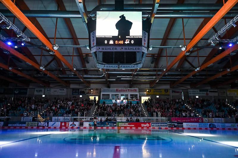Aufnahme der Eisarena in Bremerhaven kurz vor Spielbeginn. Das Licht in der Halle ist gedämmt, auf den Tribünen sind Fans zu sehen.