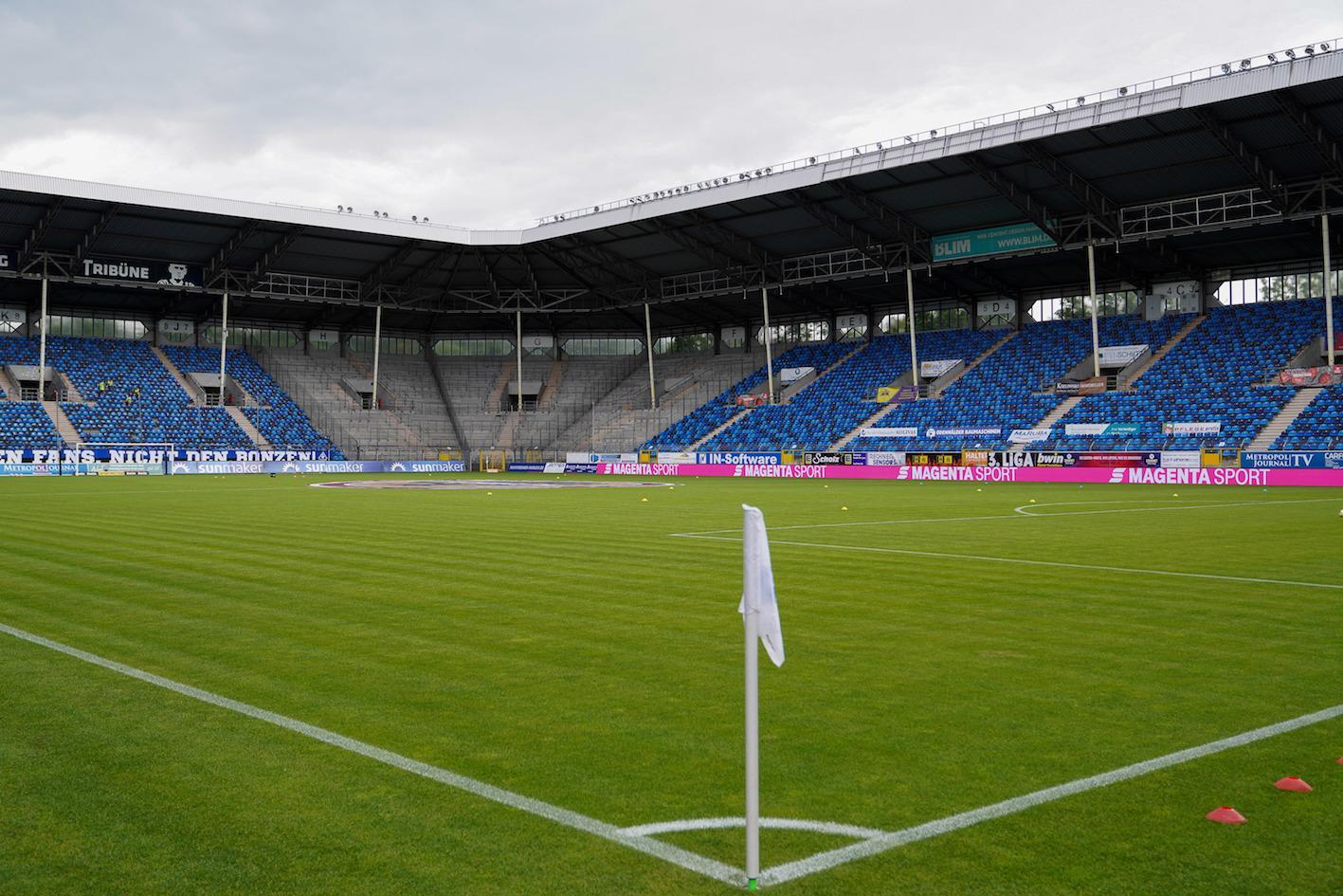 Aufnahme des Carl-Benz-Stadions in Mannheim. Im Vordergrund ist eine Eckfahne zu erkennen, im Hintergrund befinden sich die Tribünen des Stadions.