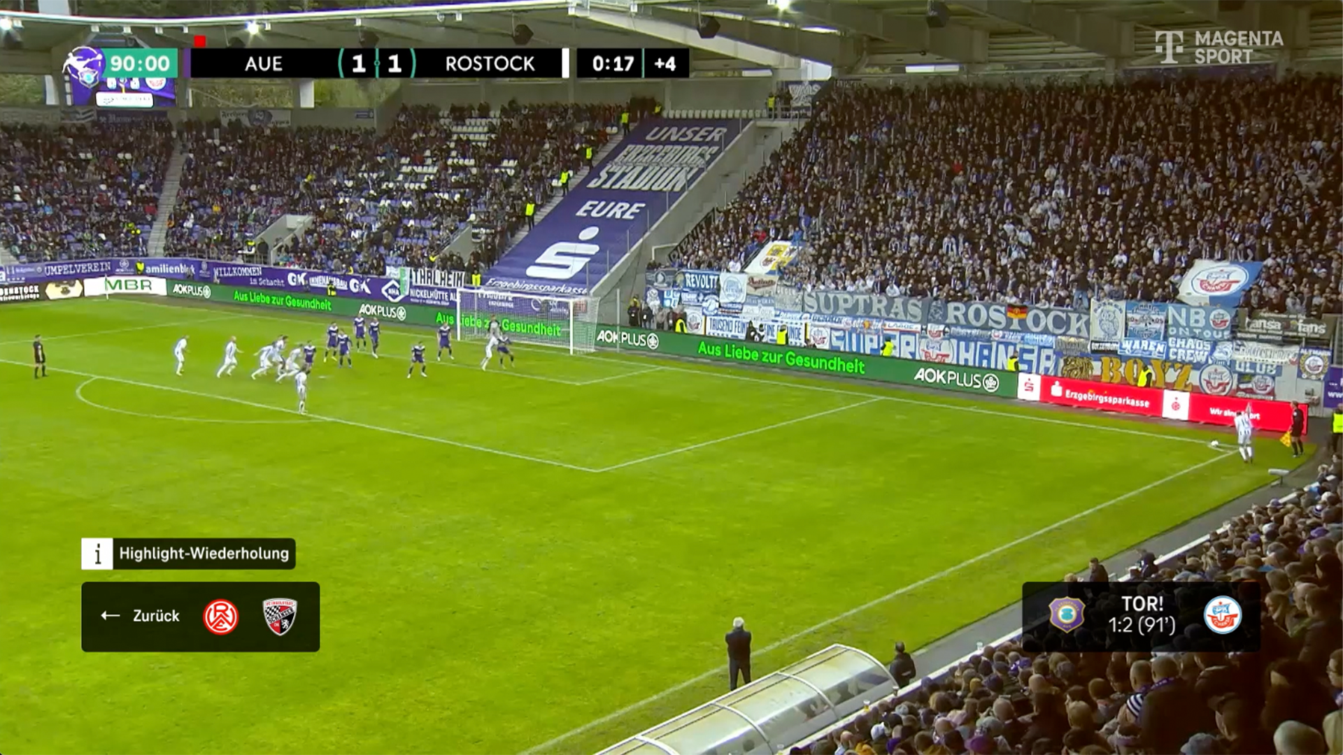 Ein Fußballspiel zwischen Aue und Rostock, bei dem eine Ecke ausgeführt wird. Unten sind zwei Elemente des Highlight-Tickers abgebildet.